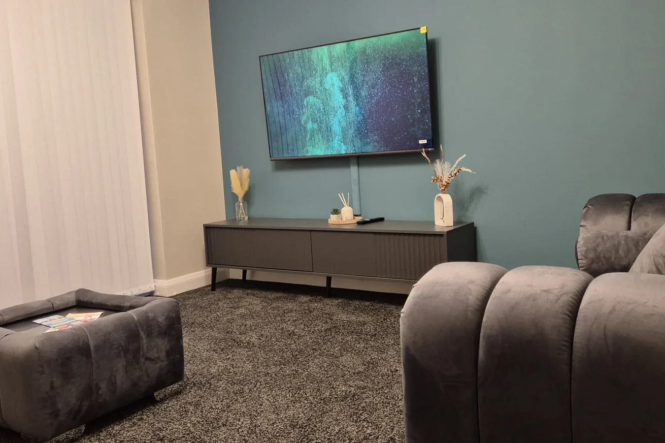 Welcoming shared lounge with comfortable sofas, television and tidy furnishings